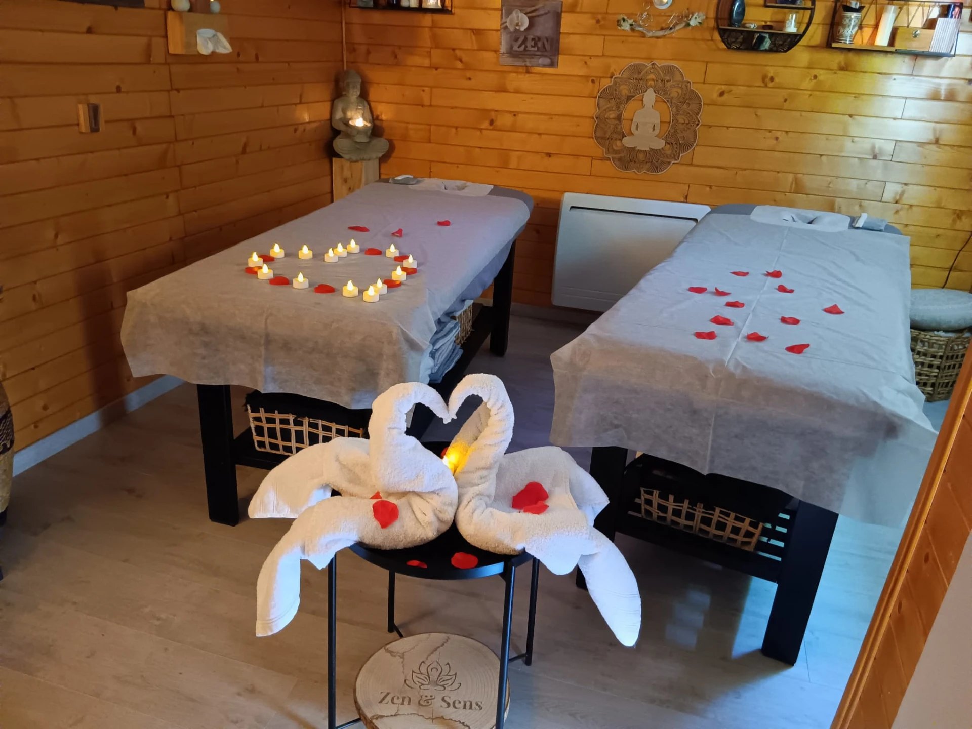 Cabine de massage pour deux : deux tables dressées avec pétales de roses et bougies
