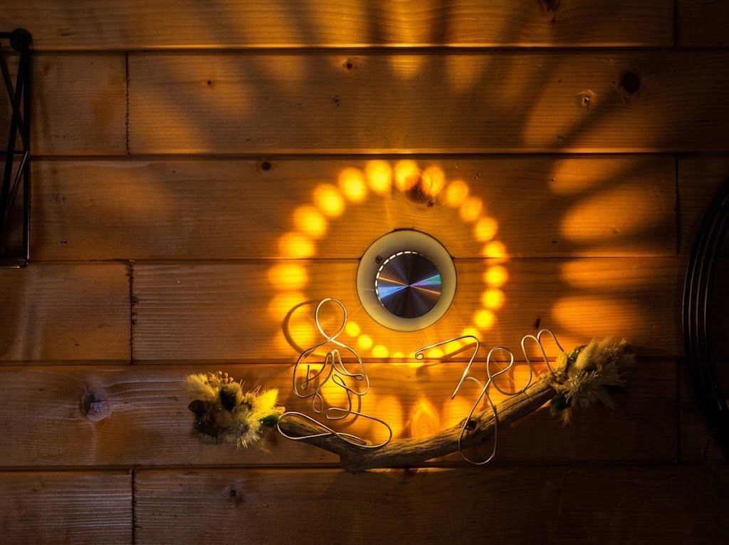 Lampe murale à lumière dorée et sculpture en fil de fer représentant une personne méditant
